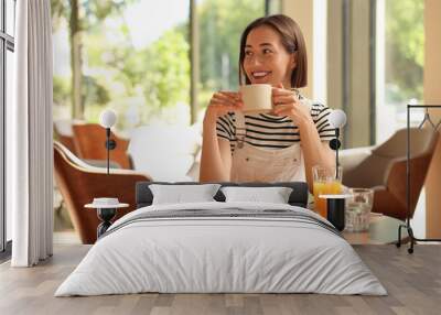 Happy woman having tasty breakfast in cafe Wall mural