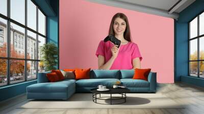 Happy woman with controller on pink background Wall mural