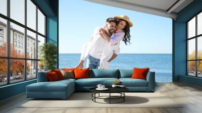 Happy young couple having fun on beach near sea. Honeymoon trip Wall mural