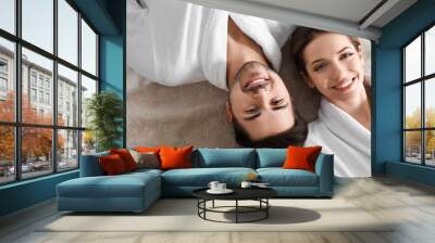 Happy young couple wearing bathrobes, top view. Visit to spa salon Wall mural