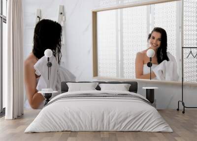 Happy young woman drying hair with towel after washing near mirror in bathroom Wall mural