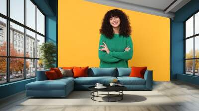 Happy young woman in stylish green sweater on yellow background Wall mural