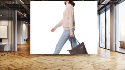 Happy young woman with stylish bag walking on white background Wall mural