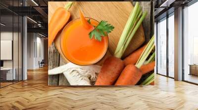 Healthy juice in glass and fresh carrot on wooden table, flat lay Wall mural