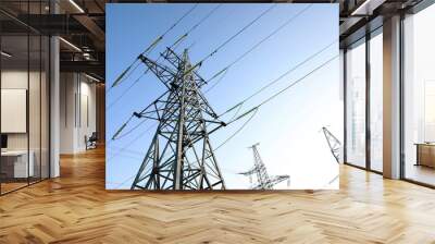 High voltage tower against blue sky on sunny day, low angle view Wall mural