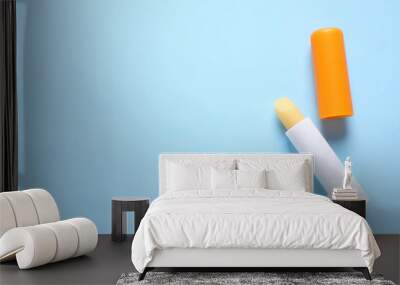 Hygienic lipstick on light blue background, flat lay. Space for text Wall mural