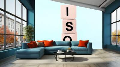 International Organization for Standardization. Wooden cubes with abbreviation ISO on light blue background, closeup Wall mural