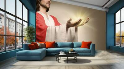 Jesus Christ on beige background, closeup. Miraculous light in hands Wall mural