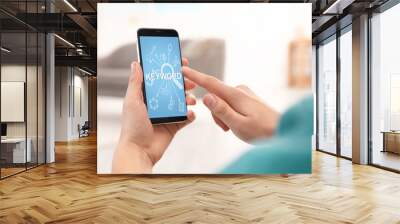 Keywords research concept. Man using smartphone indoors, closeup Wall mural