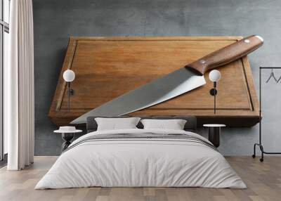 Knife and wooden board on grey textured table Wall mural