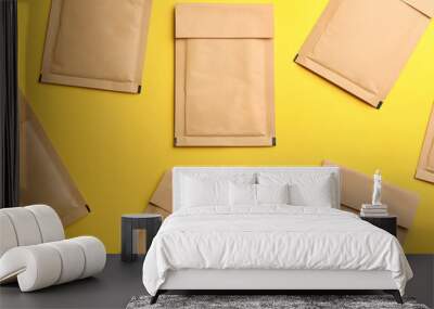 Kraft paper envelopes on yellow background, flat lay Wall mural