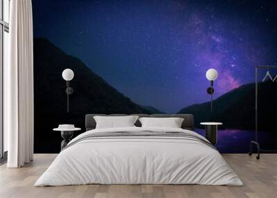 Lake with reflection of starry sky near mountains. Amazing night landscape Wall mural