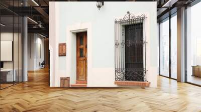 Light blue building with wooden door and window Wall mural