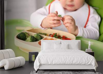 Little baby eating food in high chair, closeup Wall mural