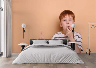 Little boy blowing whistle on beige background, space for text Wall mural