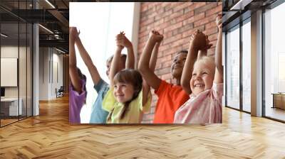 Little children holding hands together indoors. Unity concept Wall mural