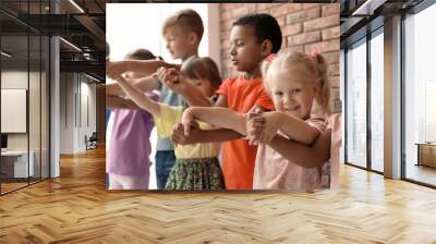 Little children holding hands together indoors. Unity concept Wall mural