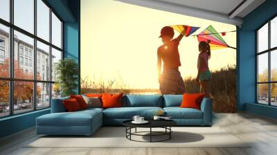 Little children playing with kites outdoors at sunset. Spending time in nature Wall mural