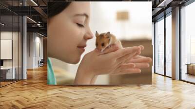 Little girl holding cute hamster at home, closeup Wall mural