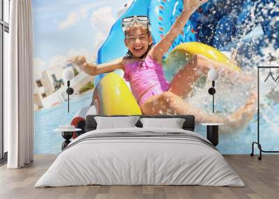 Little girl on slide at water park. Summer vacation Wall mural