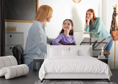 Little girl with her teacher and mother at music lesson. Learning notes Wall mural