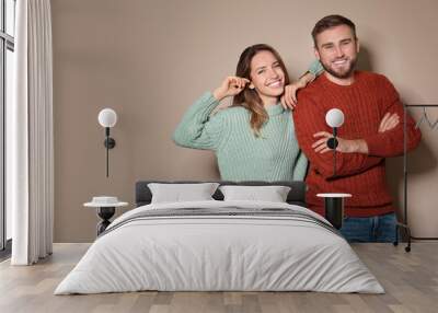 Lovely couple in warm sweaters on beige background. Space for text Wall mural