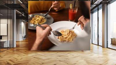 Lovely young couple having pasta carbonara for dinner at restaurant, closeup view Wall mural