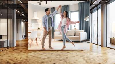 Lovely young interracial couple dancing at home Wall mural