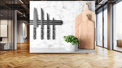 Magnetic holder with set of knives on marble wall in kitchen Wall mural