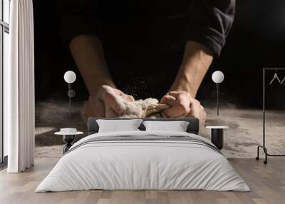 Making bread. Woman kneading dough at table on dark background, closeup Wall mural