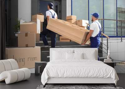 Male movers carrying shelving unit into new house Wall mural