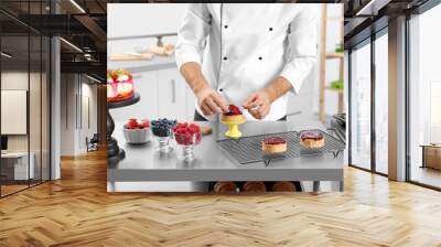 Male pastry chef preparing dessert at table in kitchen, closeup Wall mural