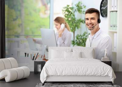 Male receptionist with headset at desk in office Wall mural