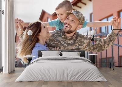 Male soldier reunited with his family outdoors. Military service Wall mural