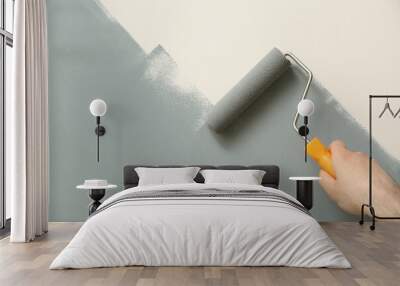 Man applying grey paint with roller brush on white wall, closeup Wall mural