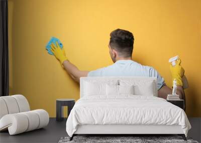 Man cleaning color wall with rag and sprayer Wall mural