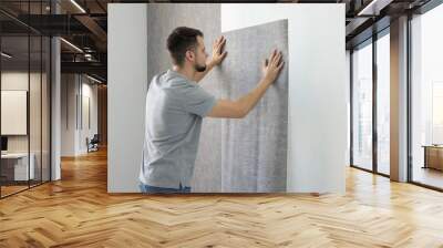 Man hanging stylish gray wallpaper in room Wall mural