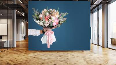 Man holding beautiful flower bouquet on blue background, closeup view. Space for text Wall mural