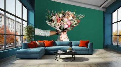 Man holding beautiful flower bouquet on green background, closeup view. Space for text Wall mural