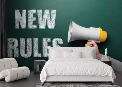 Man holding megaphone and text NEW RULES on chalkboard, closeup Wall mural