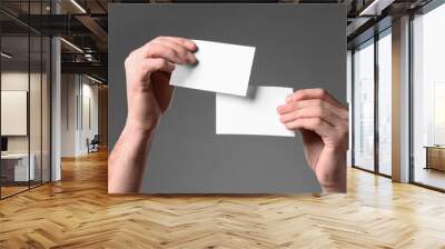 Man holding paper cards on grey background, closeup. Mockup for design Wall mural