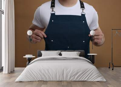 Man in kitchen apron on brown background, closeup. Mockup for design Wall mural