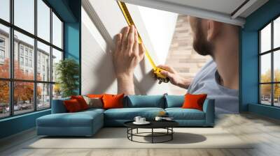 Man measuring door in room, closeup. Construction tool Wall mural