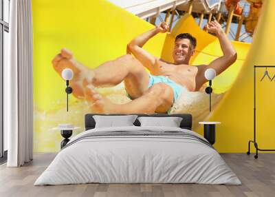 Man on slide at water park. Summer vacation Wall mural