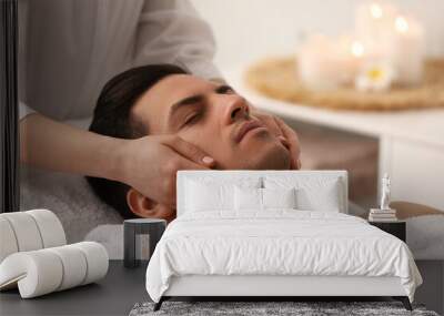 Man receiving facial massage in beauty salon Wall mural