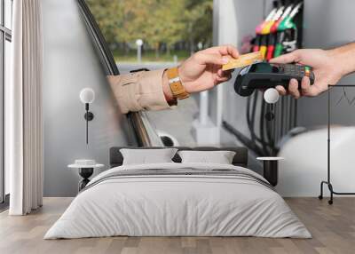 Man sitting in car and paying with credit card at gas station, closeup Wall mural