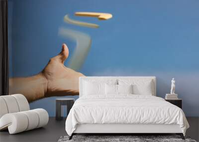 Man throwing boomerang against blue sky, closeup Wall mural