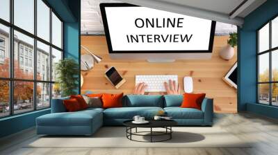 Man using computer for online job interview at table, top view Wall mural