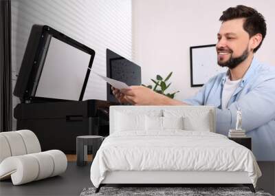 Man using modern printer at wooden table indoors Wall mural