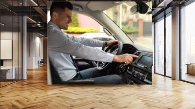 Man using navigation system while driving car Wall mural